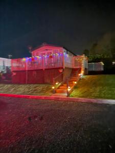 a house with a deck with lights on it at 26 Golf View in Jedburgh