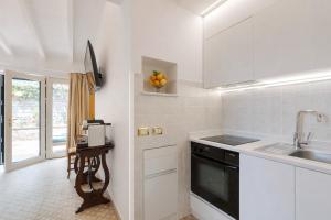 a white kitchen with a sink and a counter at GARDEN VILLA SUITE - Hotel Villa Schuler in Taormina