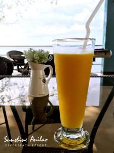 a glass of beer sitting on a table with a vase at Sunshine Anilao Dive and Beach Resort in Batangas City +30 photos