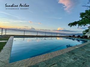 a swimming pool with a view of the ocean at Sunshine Anilao Dive and Beach Resort in Batangas City