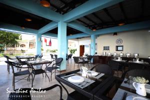 a dining room with tables and chairs in a restaurant at Sunshine Anilao Dive and Beach Resort in Batangas City
