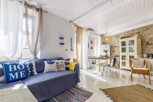 a living room with a blue couch and a table at La Casa Del Limon - Sea Views & Walkable Location in Skopelos Town