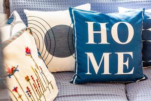 a blue pillow with the words hog me on a couch at La Casa Del Limon - Sea Views & Walkable Location in Skopelos Town +37 photos