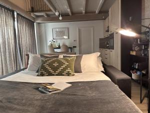 a bedroom with a bed with a book on it at The Hangar Loft - Leonoardo, Center & Parking in Sesto Calende