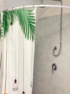 a shower with a white shower curtain and a plant at Garibaldi by LigurianLife in Vallebona