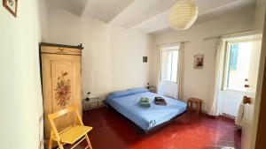 a bedroom with a bed and a chair in it at Garibaldi by LigurianLife in Vallebona