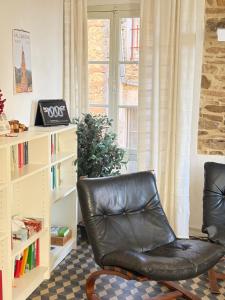 a leather chair in a living room with a book shelf at Garibaldi by LigurianLife in Vallebona