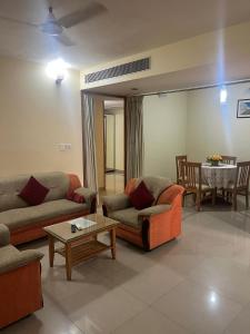 a living room with two couches and a table at Hotel Western Gatz in Theni