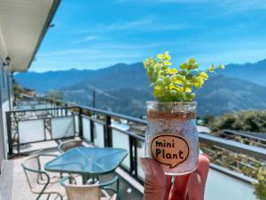 a person holding a jar with a plant in it at Water Swing B&B in Ren'ai