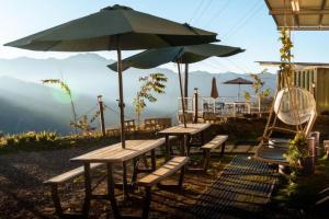 a group of picnic tables with an umbrella and chairs at Water Swing B&B in Ren'ai