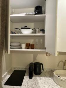 a kitchen cupboard with plates and dishes in it at Studio cosy avec parking près de Paris Expo Porte de Versailles in Vanves