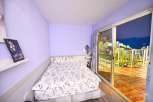 a small bedroom with a bed and a balcony at Water Swing B&B in Ren'ai