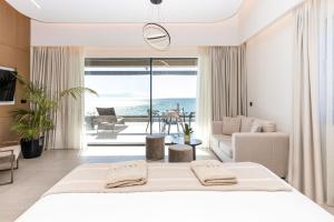 a bedroom with a bed and a view of the ocean at Anasa Luxury Resort in Elaiokhórion +72 photos