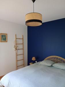 a bedroom with a blue wall and a bed at Le Clos du Perche in Boissy-lès-Perche