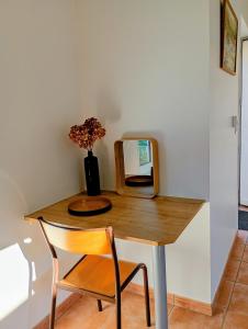 a table with a chair and a mirror on it at Le Clos du Perche in Boissy-lès-Perche