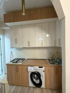 a kitchen with a washing machine and a stove at welcome apartment in Itʼkhvisi