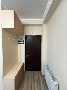 a hallway with a black door and a black closet at welcome apartment in Itʼkhvisi