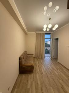 a living room with a couch and a large window at welcome apartment in Itʼkhvisi
