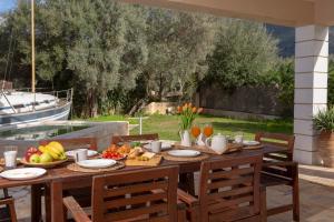 a wooden table with fruit on it on a patio at Villa Morris in Nydri
