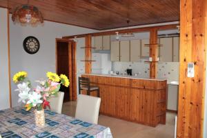 a kitchen and dining room with a table with flowers on it at Komninos' Traditional House in Artemida