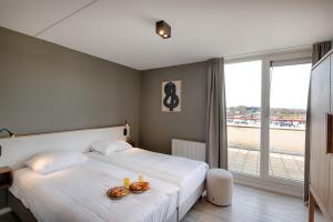 a hotel room with a bed with two donuts and candles at Resort Boschmolenplas in Heel