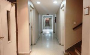 un largo pasillo con paredes blancas y un largo suelo de baldosa blanca en Apartamento El Colón en Buenos Aires