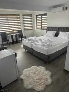 a bedroom with a large bed and a white rug at Viv House in Vălenii de Munte