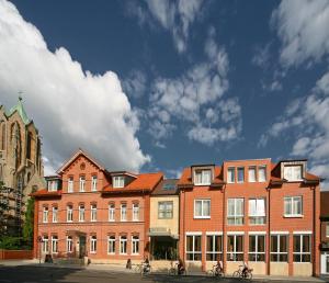 un gran edificio de ladrillo con bicicletas estacionadas frente a él en Hotel von Euch, en Meppen