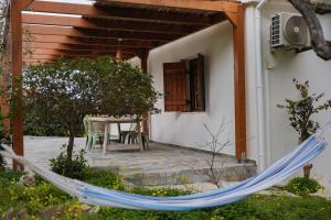 a patio with a hammock in front of a house at Dia View Retreat in Elaía