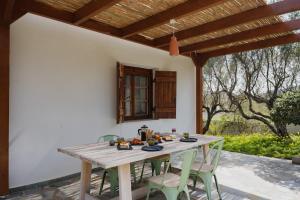a wooden table and chairs under a wooden pergola at Dia View Retreat in Elaía