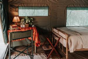 a bedroom with a bed and a table and a chair at Bunduz Mara in Sekenani +20 photos