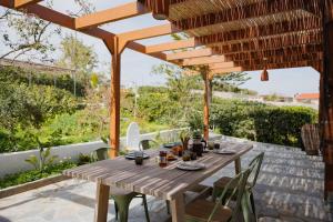a wooden table on a patio under a wooden umbrella at Dia View Retreat in Elaía