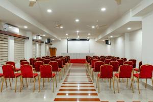 a conference room with red chairs and a screen at Hotel Lals Residency, Adoor in Adūr