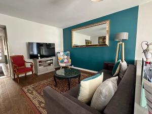 a living room with a couch and a tv at "LA VERANDA" Gîte in Verdigny