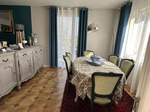 a dining room with a table and chairs and a kitchen at "LA VERANDA" Gîte in Verdigny +29 photos