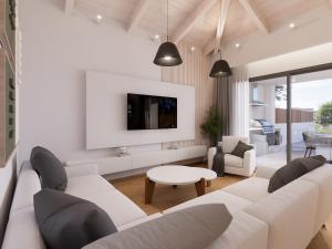 a living room with a white couch and a tv at Villa Morena in Kypseli