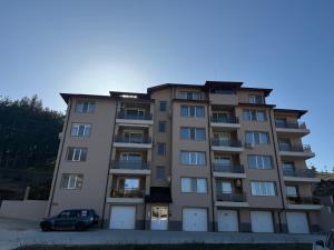 a building with a car parked in front of it at Forest Panorama Luxury Apartment in Velingrad