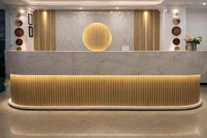 a lobby with a gold bench in front of a counter at Cherrywood at Rajpur Road by Zenvana in Dehradun +5 photos