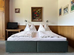 a bedroom with a bed with white sheets and a television at Chalet Cristall Superior Appartement 7 in Leutasch