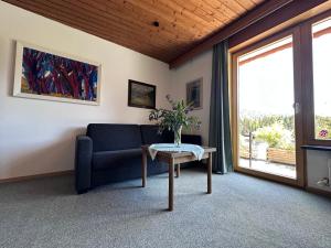 a living room with a couch and a table at Chalet Cristall Superior Appartement 7 in Leutasch +9 photos