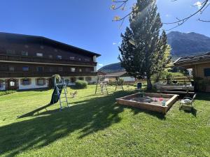 a garden with a christmas tree and a playground at Chalet Cristall Superior Appartement 7 in Leutasch