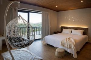 a bedroom with a swinging bed and a large window at Sweet Quintanilha in Quintanilha