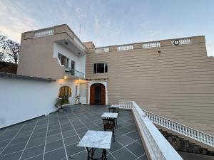 a balcony of a house with two tables and chairs at JD Tara Resort in Ranakpur