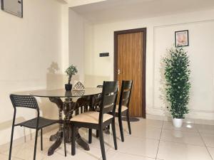 a dining room with a table and chairs and a plant at Premium 2BHK Apartment by Key Stays - Hyd in Hyderabad