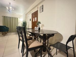 a dining room with a black table and chairs at Premium 2BHK Apartment by Key Stays - Hyd in Hyderabad +6 photos