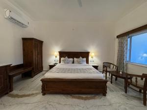 a bedroom with a large bed and a window at JD Tara Resort in Ranakpur