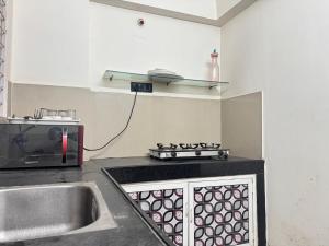 a kitchen with a sink and a microwave at Premium 2BHK Apartment by Key Stays - Hyd in Hyderabad