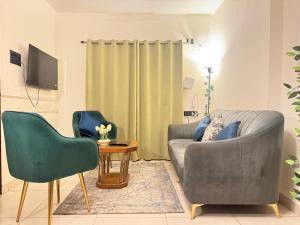 a living room with a gray couch and two chairs at Premium 2BHK Apartment by Key Stays - Hyd in Hyderabad
