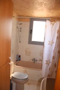 a bathroom with a toilet and a bath tub at Komninos' Traditional House in Artemida +25 photos