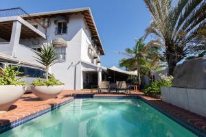 a swimming pool in front of a house at Marilyn Boutique Hotel in Durban